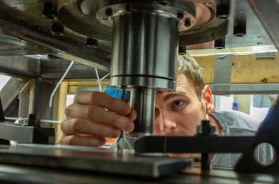 Student works on 3-d printing machine